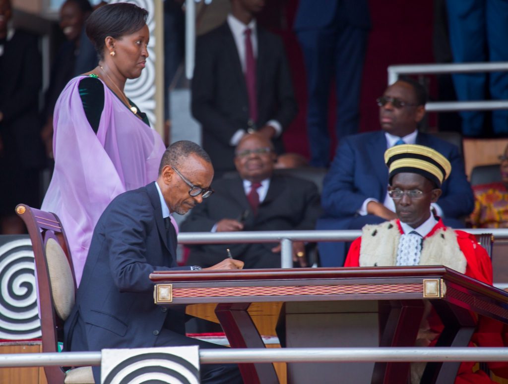 Kagame fulfilling official ceremonies during Friday's swearing in as his wife Jeanette Kagame (standing) looks on